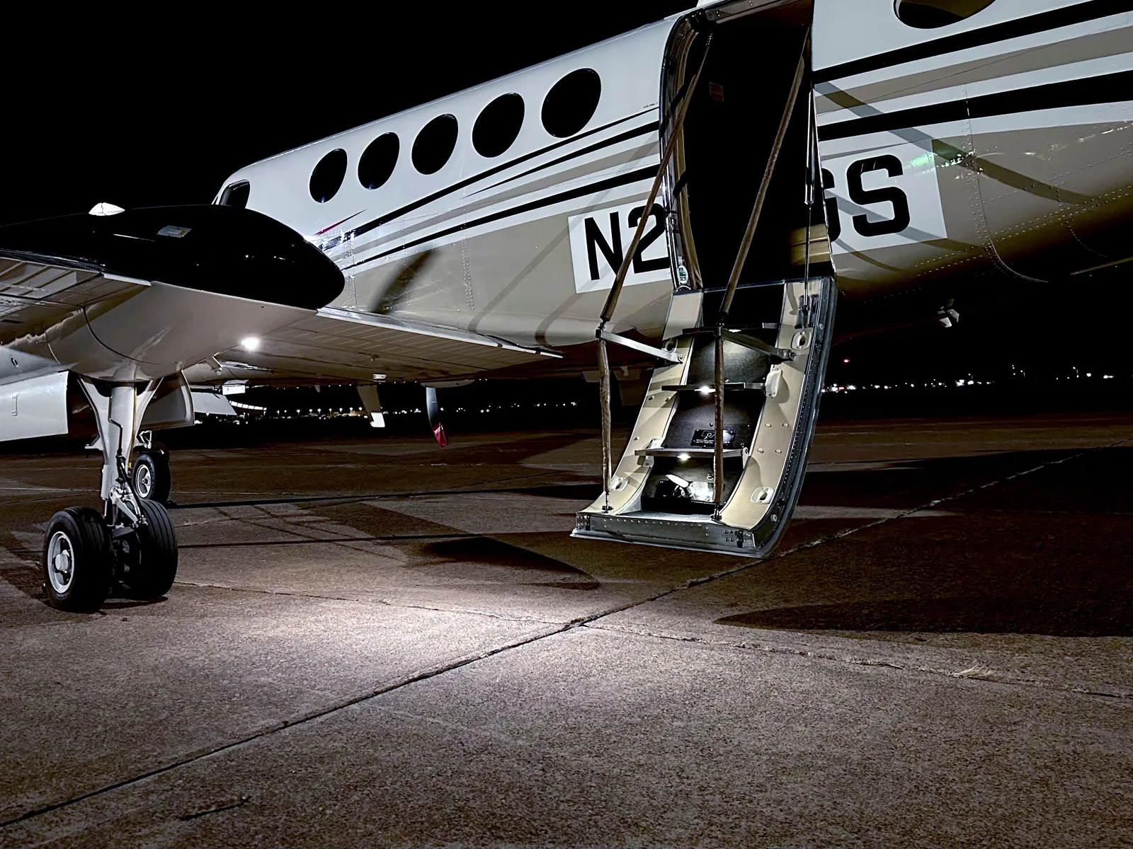 PWI LED entry door underwing light illuminating King Air aircraft at night