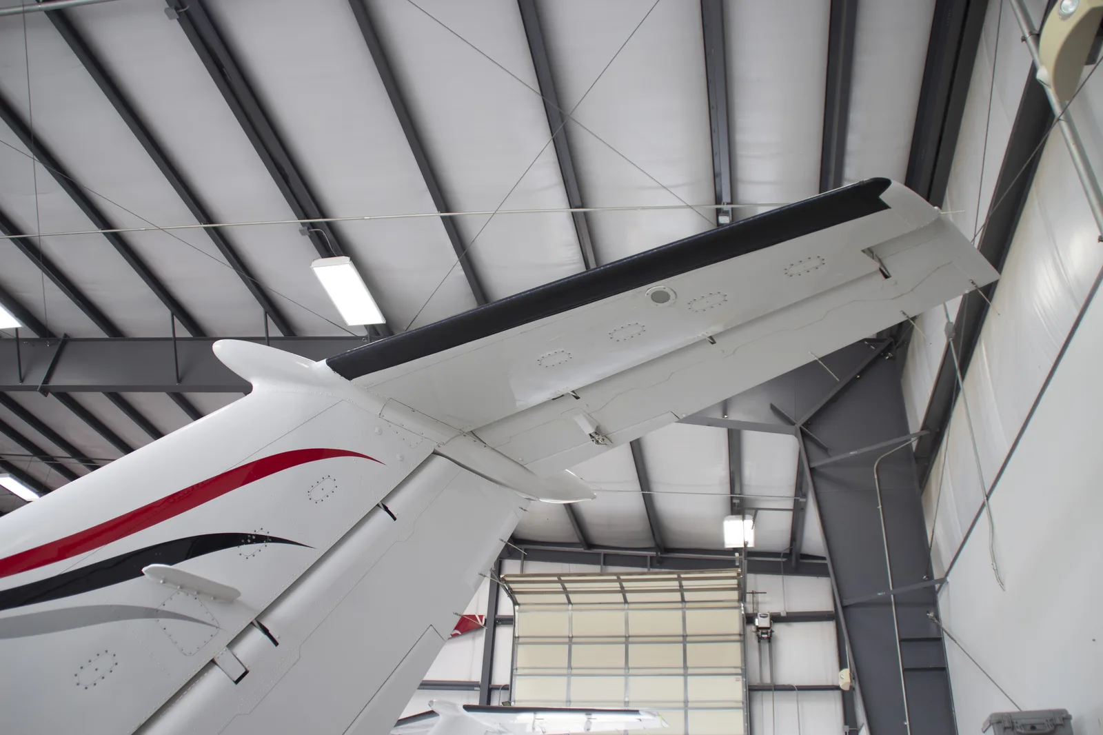 PWI LED logo light &mdash; installed on aircraft wing underside in hangar