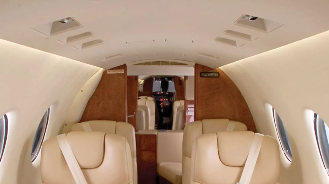 PWI Beechjet 400 LED cabin interior, cream leather seats with warm LED overhead lighting looking forward toward cockpit