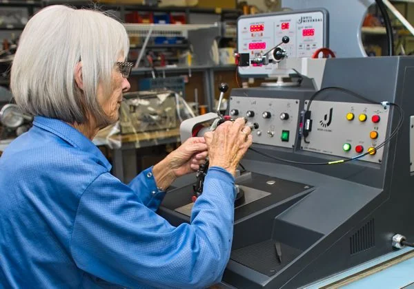 PWI technician operating a coil winding machine